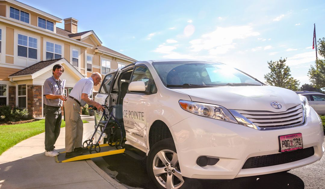 Elderly man with walker being helped into a white van